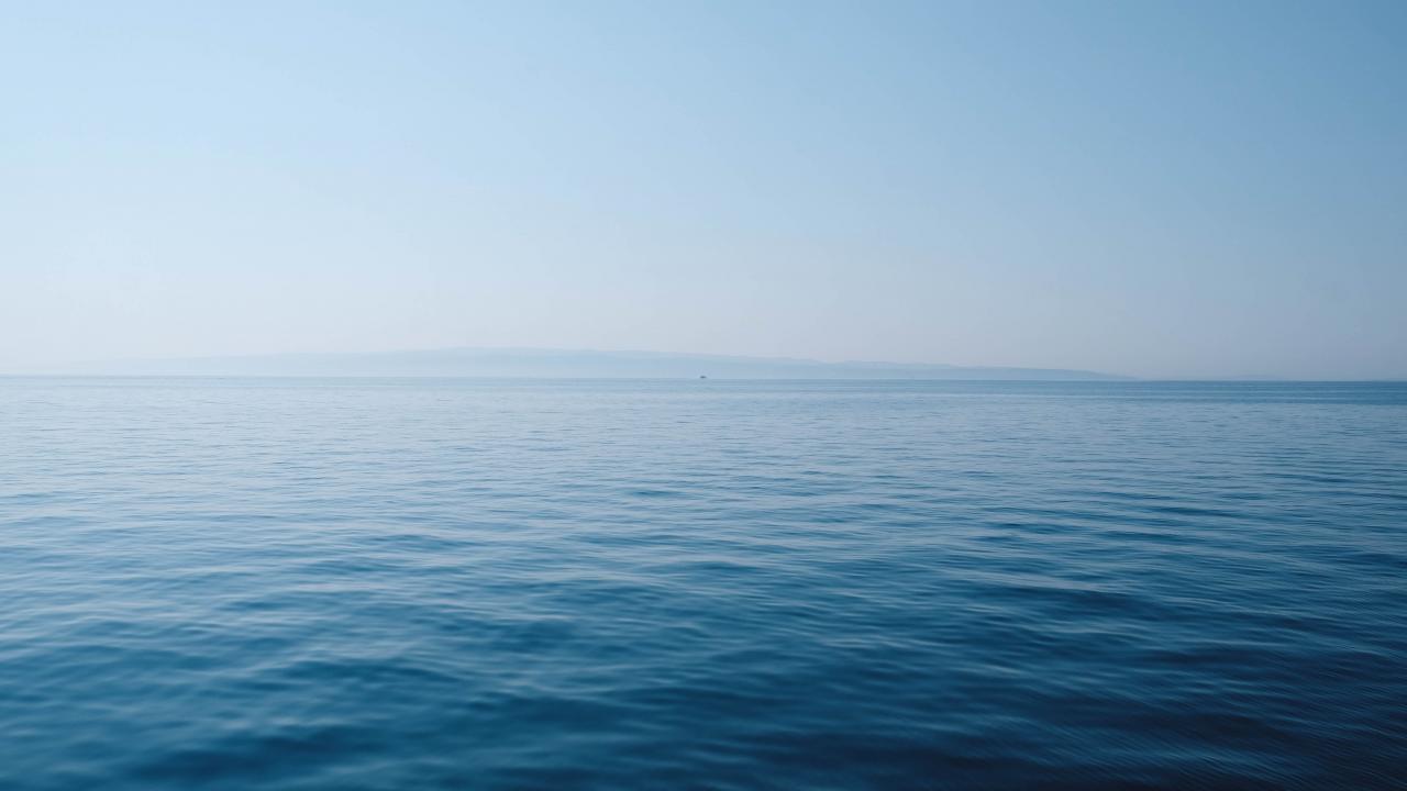Image courtesy of Thomas Vimare on Unsplash Ocean horizon with small ripples on surface
