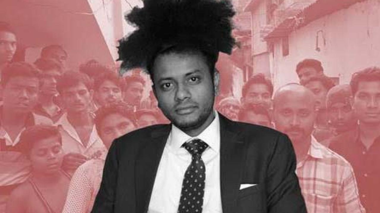 Black and white image of Dr. Suraj Yengde highlighted in front of a crowd of people