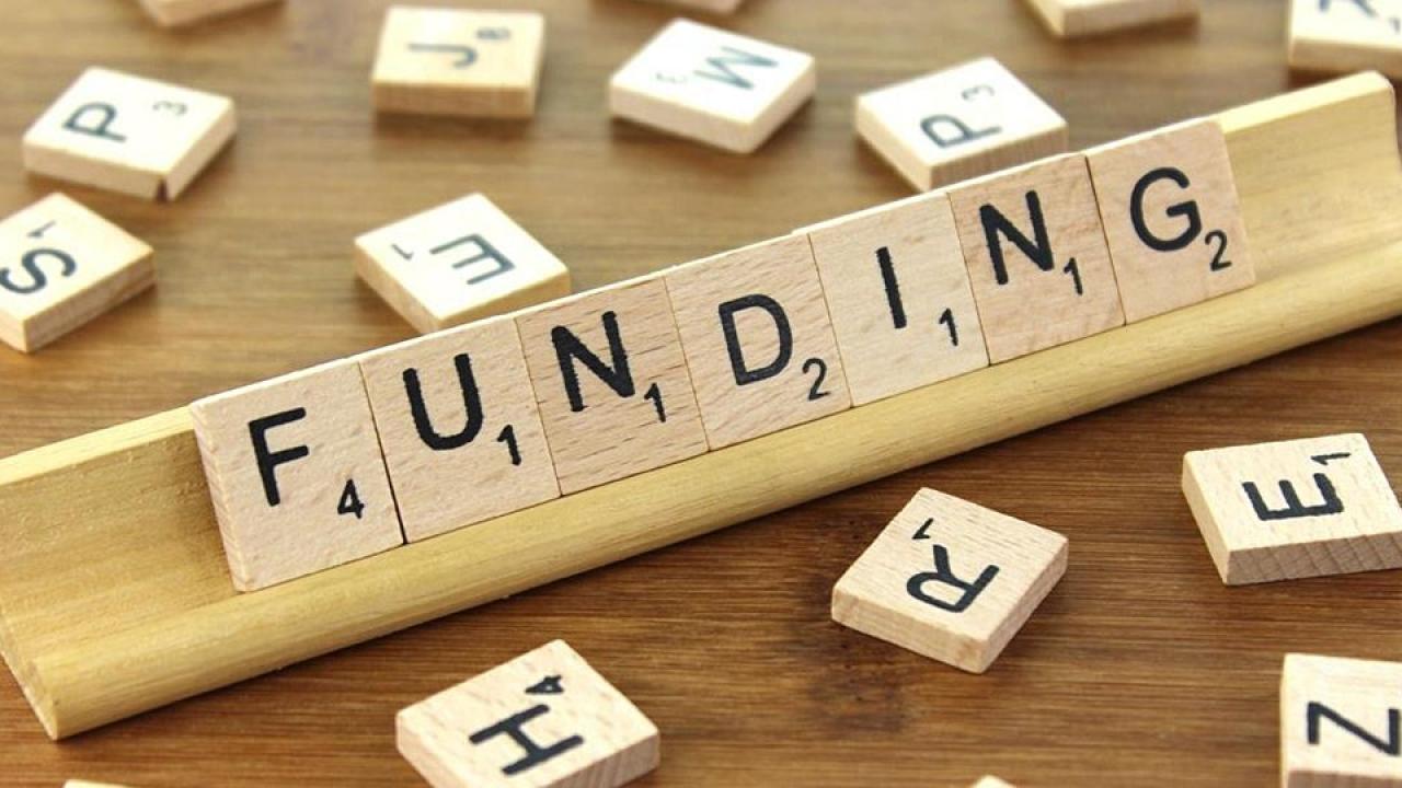 Scrabble tiles spelling out "FUNDING"