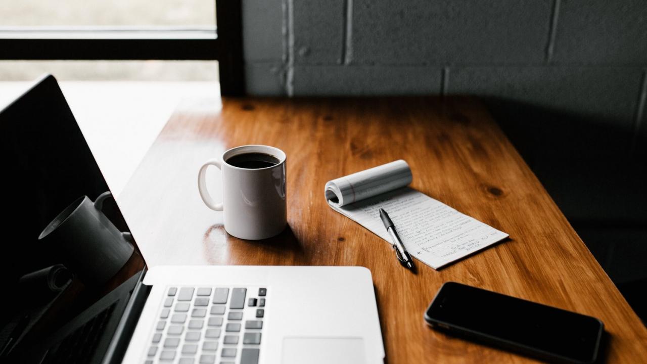 Laptop, coffee mug, and notepad