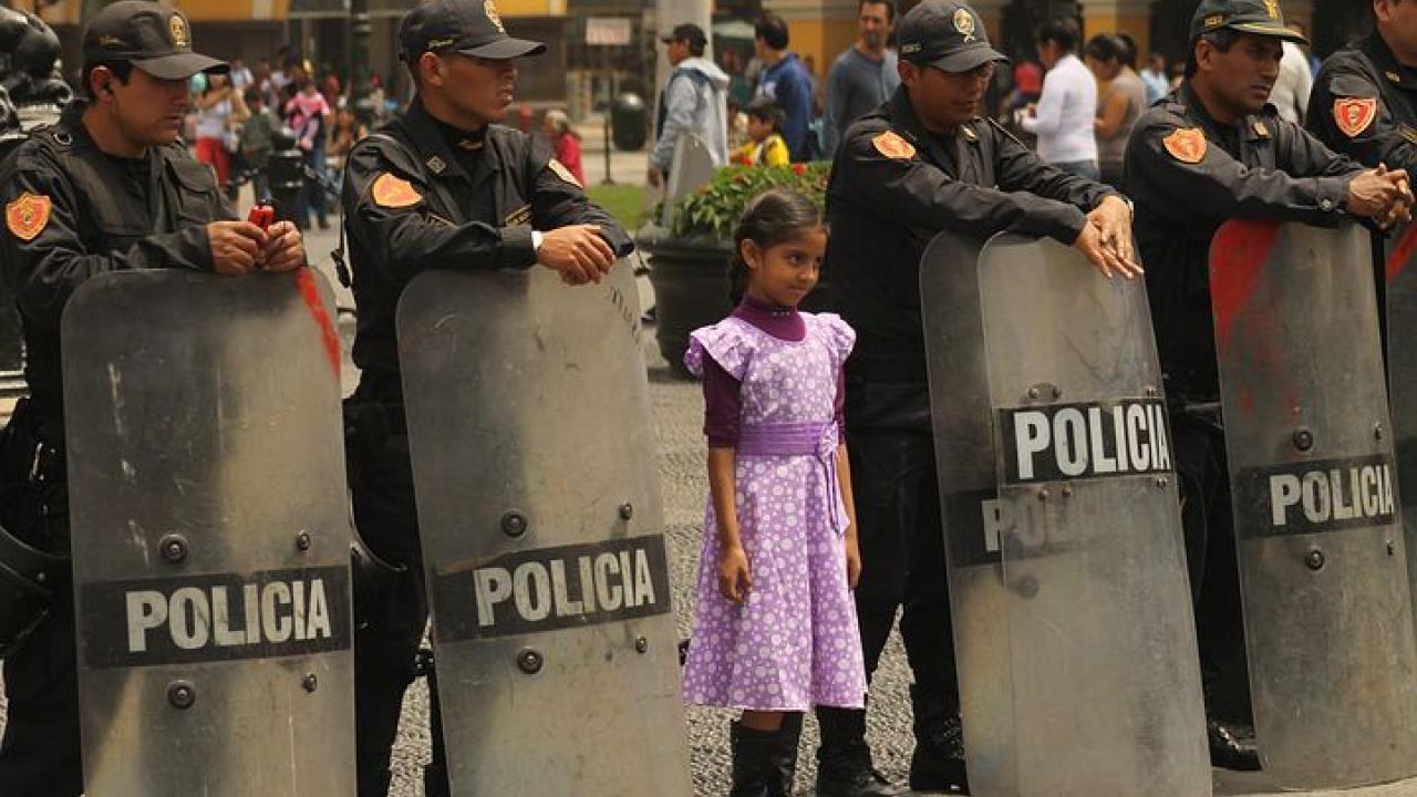 girl standing between police shields