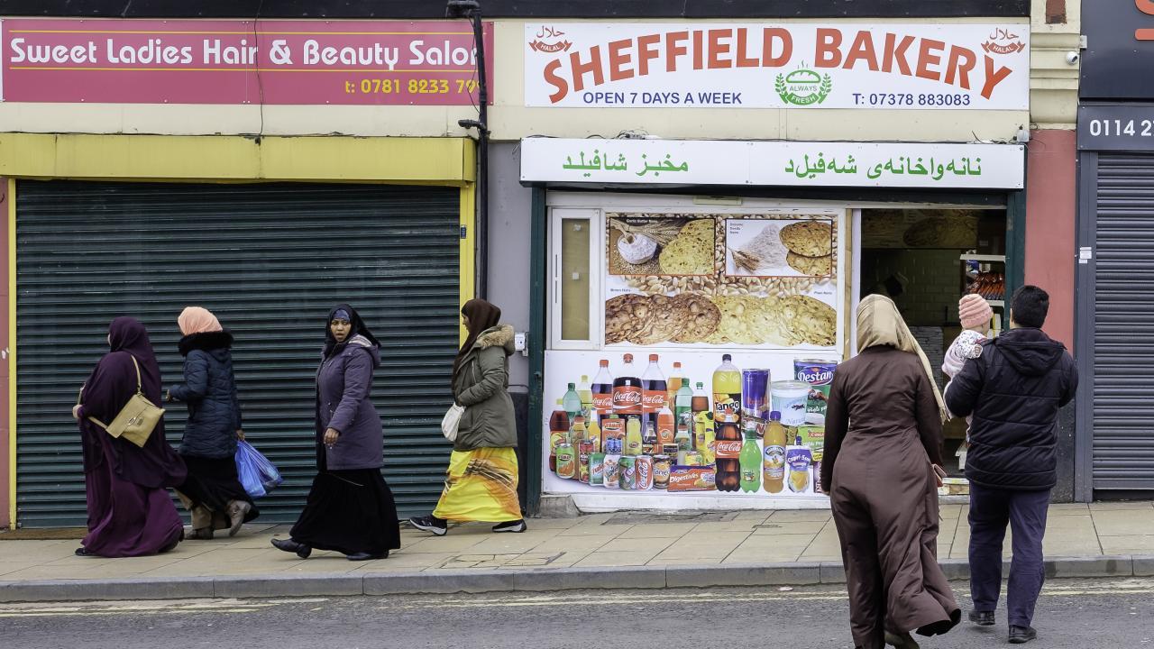 shopfronts with people walking in front of them