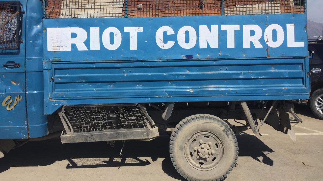 Rusty blue truck with white lettering that reads "RIOT CONTROL"