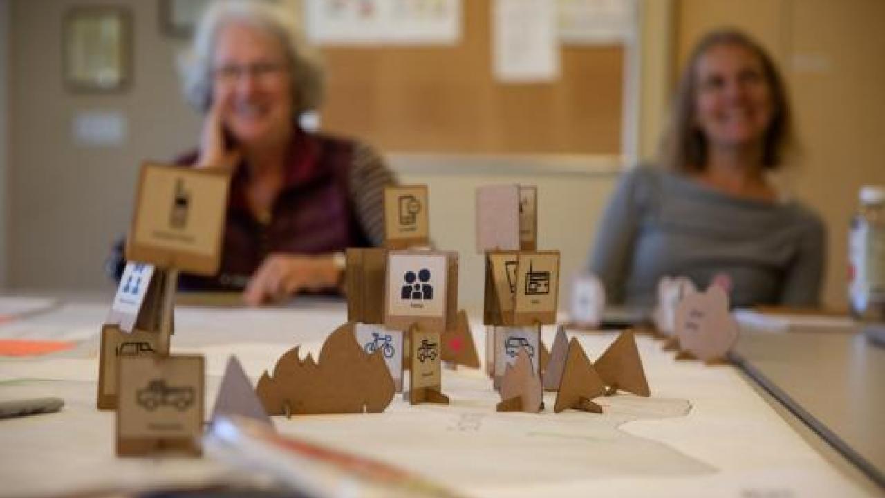 Image of people playing Wildfire Evacuation, a board game co-developed by Thomas Maiorana