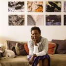 Portrait of Claudia Rankine sitting on couch with her dog