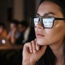 Person working at computer with screen reflected in their glasses