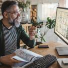 Person with beard and glasses teaching to computer screen 